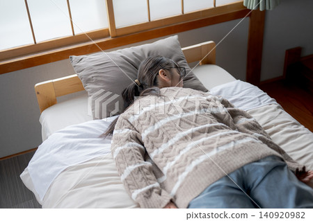A woman resting face down in bed A woman resting face down in bed 140920982