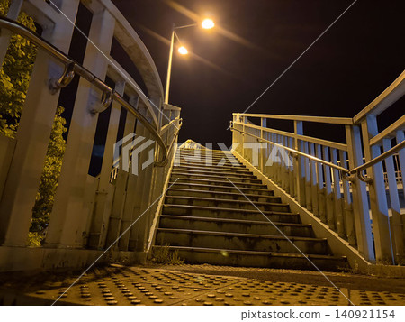 一張從低角度拍攝的風景照片,展現了通往夜空的廢棄人行天橋階梯。 一張從低角度拍攝的風景照片,展現了通往夜空的廢棄人行天橋階梯。 140921154