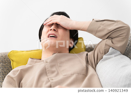 A young man taking a nap on a sofa - Lifestyle image A young man taking a nap on a sofa - Lifestyle image 140921349