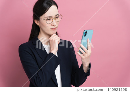 A businesswoman using a smartphone: Business image A businesswoman using a smartphone: Business image 140921398