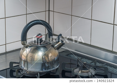 A metal kettle on a gas stove A metal kettle on a gas stove 140921824