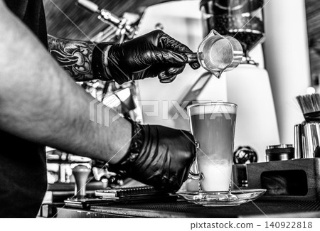 Barista at premium coffee shop preparing a Latte with professional equipment in Black & White 140922818