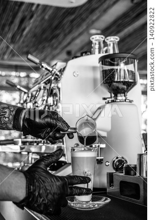 Barista at premium coffee shop preparing a Latte with professional equipment in Black & White Barista at premium coffee shop preparing a Latte with professional equipment in Black & White 140922822
