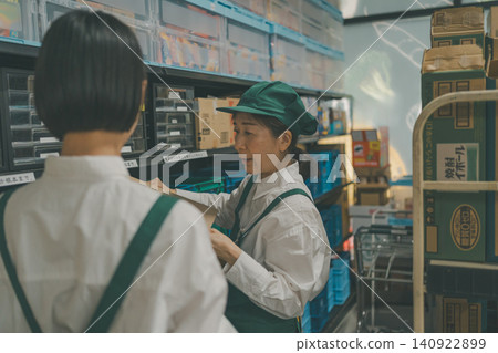 A senior staff member explaining something to a junior staff member in the back room. A senior staff member explaining something to a junior staff member in the back room. 140922899