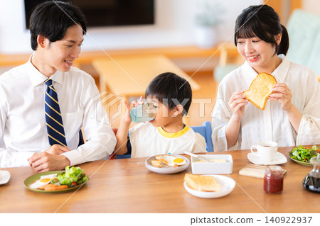 A family of three eating breakfast before going to work or school. A family of three eating breakfast before going to work or school. 140922937