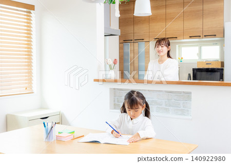 A child studying in the living room, watched over by their mother. A child studying in the living room, watched over by their mother. 140922980