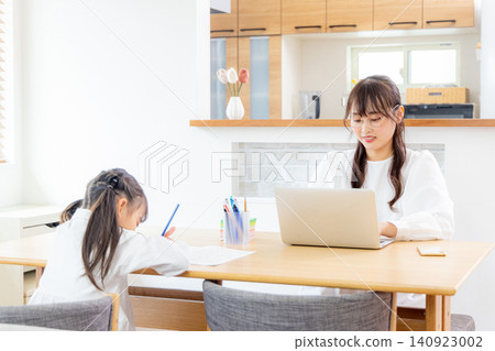 A child studying in the living room and a working mother. A child studying in the living room and a working mother. 140923002