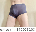 A man with metabolic syndrome in his underwear, facing right, wearing blue. 140923103