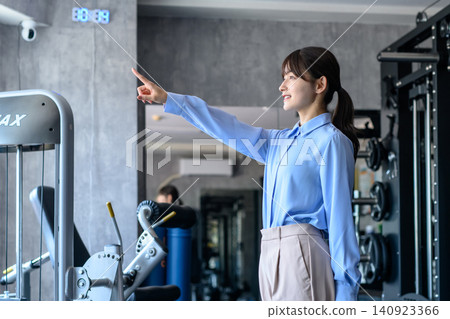 A young woman in office casual attire heads to the gym after work; a fitness enthusiast; dieting; trimming up. A young woman in office casual attire heads to the gym after work; a fitness enthusiast; dieting; trimming up. 140923366