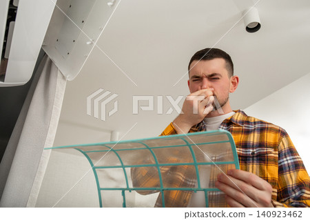 Air conditioner technician examines dirty filter indoors Air conditioner technician examines dirty filter indoors 140923462