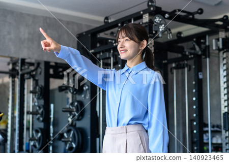 一位身著休閒職業裝的年輕女子下班後前往健身房;她是一位健身愛好者;正在節食;想要瘦身。 一位身著休閒職業裝的年輕女子下班後前往健身房;她是一位健身愛好者;正在節食;想要瘦身。 140923465