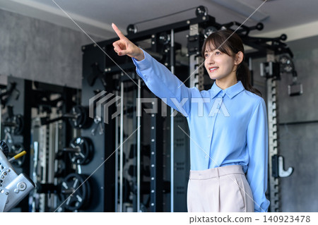 一位身著休閒職業裝的年輕女子下班後前往健身房；她是一位健身愛好者；正在節食；想要瘦身。 140923478