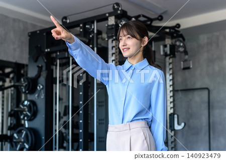 一位身著休閒職業裝的年輕女子下班後前往健身房；健身愛好者；正在節食；以人物為中心的裁剪圖像。 140923479