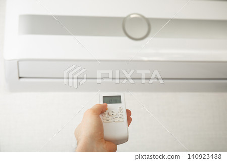 User adjusts air conditioner settings for ideal indoor climate User adjusts air conditioner settings for ideal indoor climate 140923488