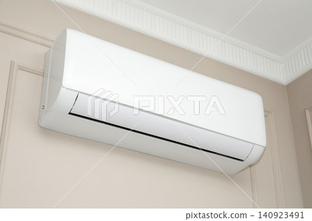 Air conditioner cools indoor space. Comfort and energy efficiency concept Air conditioner cools indoor space. Comfort and energy efficiency concept 140923491