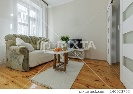 Cozy Living Room Interior with Staged Coffee Table and Sofa Cozy Living Room Interior with Staged Coffee Table and Sofa 140923703
