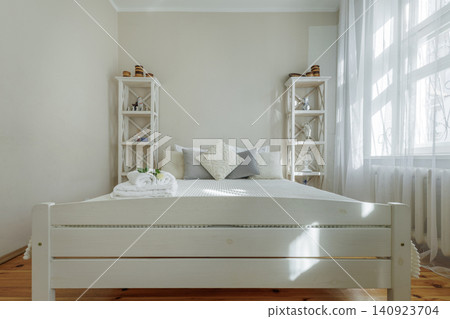Symmetrical Bedroom Interior with White Wooden Bed and Shelves Symmetrical Bedroom Interior with White Wooden Bed and Shelves 140923704