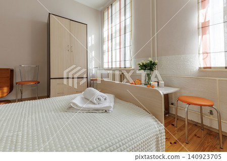 Cozy Bedroom Interior with Wooden Wardrobe and Orange Chairs 140923705