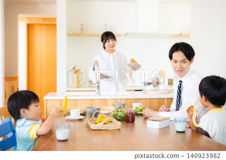 A family of four eating breakfast before going to work or school. A family of four eating breakfast before going to work or school. 140923982