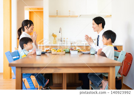 A family of four eating breakfast before going to work or school. A family of four eating breakfast before going to work or school. 140923992
