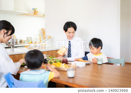 A family of four eating breakfast before going to work or school. A family of four eating breakfast before going to work or school. 140923998