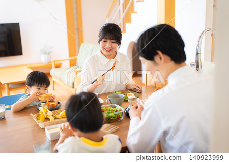 A family of four eating breakfast before going to work or school. A family of four eating breakfast before going to work or school. 140923999