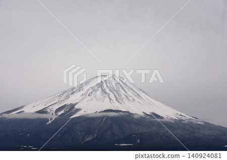 富士山白雪皚皚的山頂與白雲密佈的天空完美融合，而樹線以下的積雪覆蓋的山坡則呈現出灰濛濛的色調。 140924081