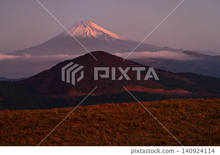 從伊豆半島伊豆山脊步道的仁名峠展望台上可以看到日出時的富士山和玉井山。 從伊豆半島伊豆山脊步道的仁名峠展望台上可以看到日出時的富士山和玉井山。 140924114