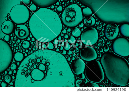 Macro view of teal liquid droplets clustered on dark background, creating organic circular cells, glossy surfaces, and scientific abstract texture Macro view of teal liquid droplets clustered on dark background, creating organic circular cells, glossy surfaces, and scientific abstract texture 140924198