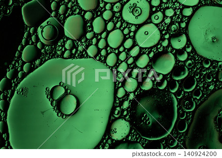 Close view of green circular droplets suspended on dark fluid surface, forming organic bubble patterns with glossy highlights and rich contrast Close view of green circular droplets suspended on dark fluid surface, forming organic bubble patterns with glossy highlights and rich contrast 140924200