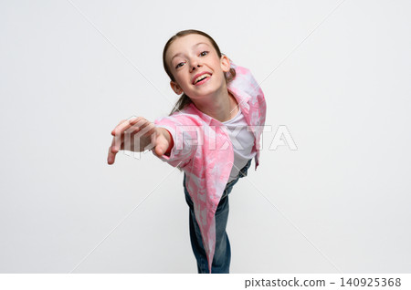 Cheerful teenage girl reaching toward camera with outstretched hand. Cheerful teenage girl reaching toward camera with outstretched hand. 140925368
