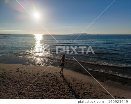 Young Woman Jogging on Sandy Beach at Sunrise along Sea Young Woman Jogging on Sandy Beach at Sunrise along Sea 140925449