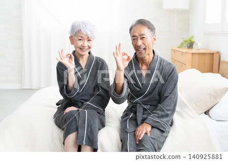 一對老年夫婦穿著長袍坐在床上,生活方式圖片 一對老年夫婦穿著長袍坐在床上,生活方式圖片 140925881