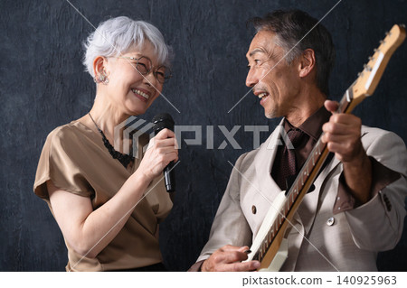 A woman singing and a man playing the guitar Lifestyle image A woman singing and a man playing the guitar Lifestyle image 140925963