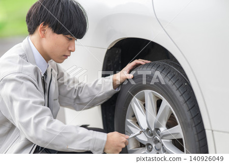 A young mechanic inspecting tires 140926049
