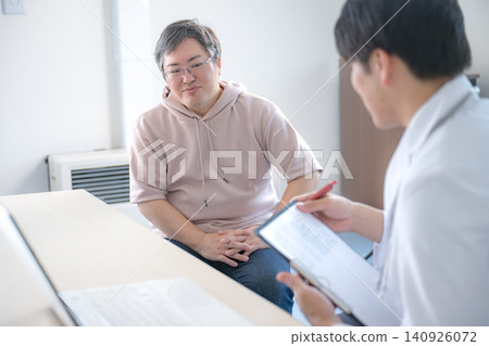 一位中年男子正在診間諮詢醫生。 一位中年男子正在診間諮詢醫生。 140926072