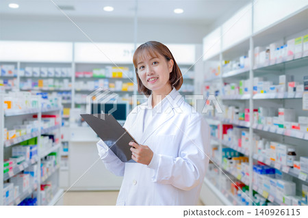 Female pharmacist managing medications at a pharmacy Female pharmacist managing medications at a pharmacy 140926115
