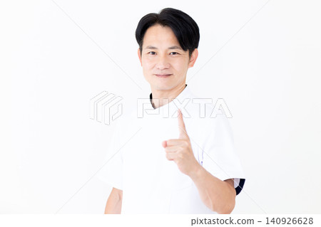 一位身穿白大褂的中年男性針灸師/整骨師,舉起他的食指。 一位身穿白大褂的中年男性針灸師/整骨師,舉起他的食指。 140926628