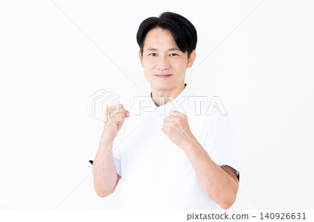 A middle-aged male acupuncturist/osteopath in a white coat makes a victory pose. A middle-aged male acupuncturist/osteopath in a white coat makes a victory pose. 140926631