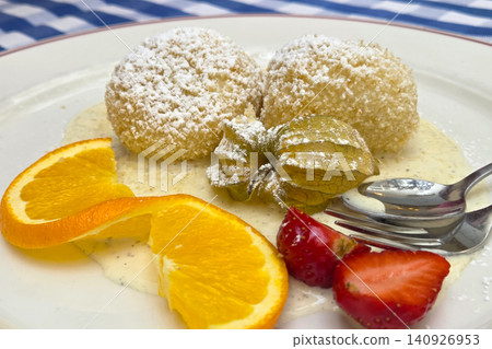 Delicious Dessert Plate with Dumplings, Fresh Fruits, and Vanilla Sauce for Gourmet Dining 140926953
