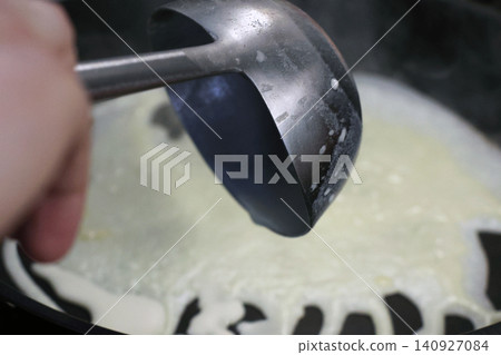 Cooking in Progress: Pouring Batter onto Hot Skillet for Perfect Pancakes Cooking in Progress: Pouring Batter onto Hot Skillet for Perfect Pancakes 140927084