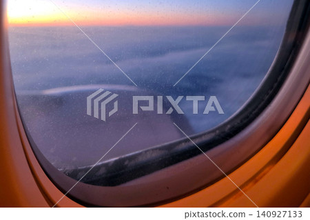 Sunset view from airplane window during flight over clouds at high altitude 140927133