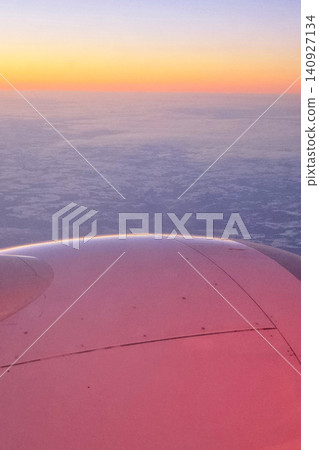 Beautiful view from an airplane window with clouds and sunset over the landscape 140927134