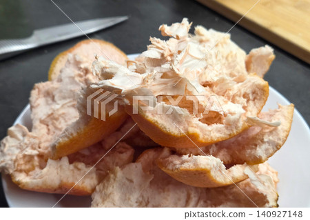 Peeling orange and removing pulp in kitchen during afternoon Peeling orange and removing pulp in kitchen during afternoon 140927148