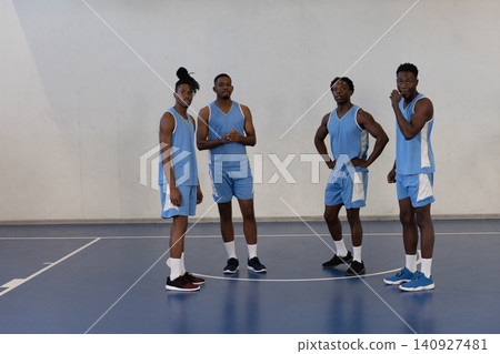 African american male teammates in line on gym court wearing matching jerseys and shoes African american male teammates in line on gym court wearing matching jerseys and shoes 140927481