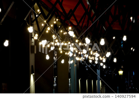 Ambient String Lights Adorning Urban Cafe Patio at Night Ambient String Lights Adorning Urban Cafe Patio at Night 140927594