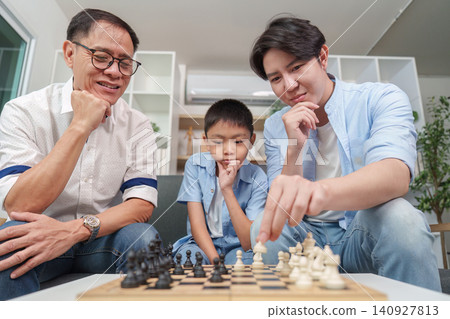 Multigenerational Asian family playing chess at home for cognitive learning Multigenerational Asian family playing chess at home for cognitive learning 140927813