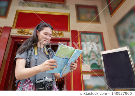 Asian woman tourist looking at map for travel and exploration 140927900