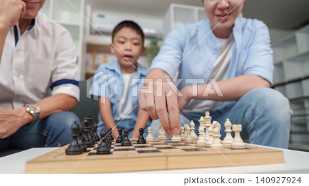 Close up of Asian family playing chess board game at home Close up of Asian family playing chess board game at home 140927924