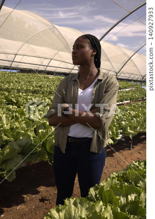 African american woman standing arms crossed, checking lettuce beds with smartwatch African american woman standing arms crossed, checking lettuce beds with smartwatch 140927933